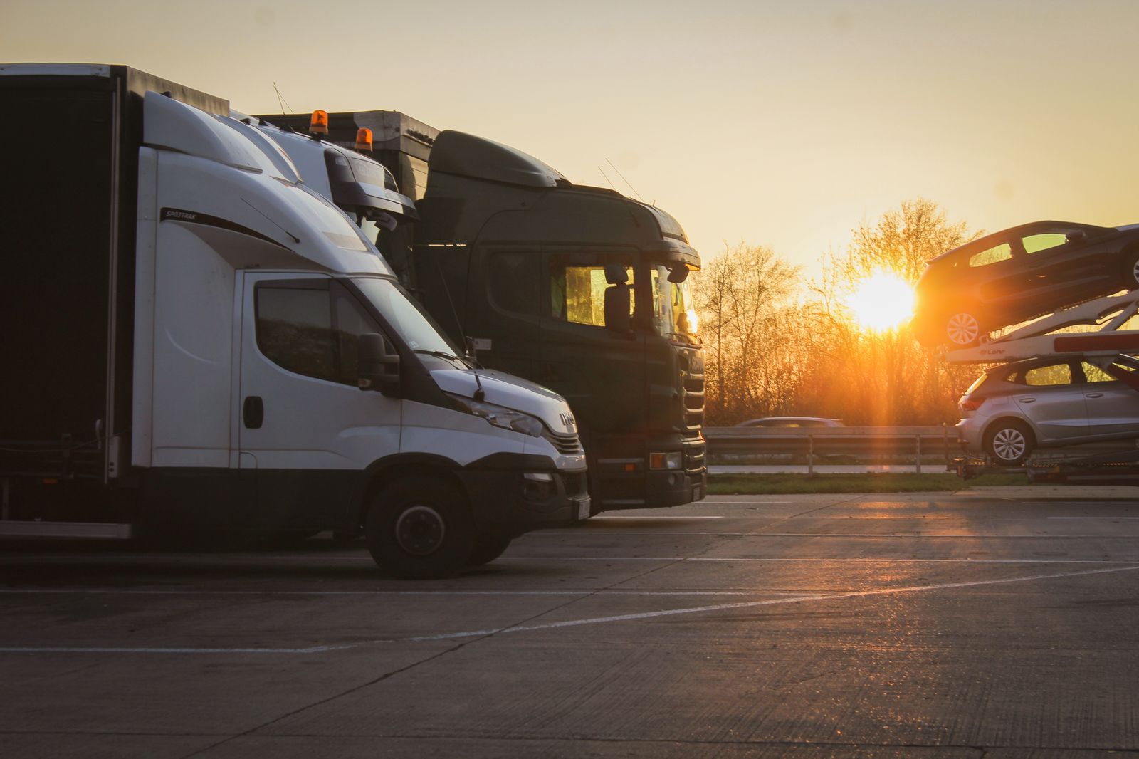 Trucks parked in an open lot at sunset during golden hour